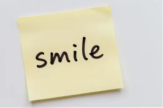 Yellow Sticky Note with Cursive 'Smile' Text cursive smile