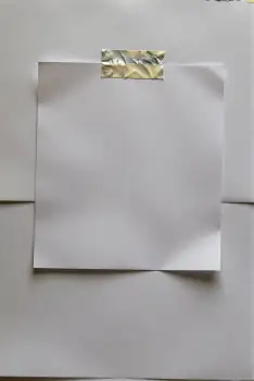 White Paper on Wall with Silver Tape taped blank sticky note