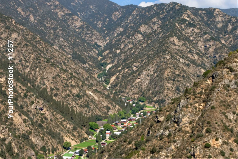 Mountain Landscape with Town rocky peaks green vegetation