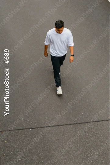 Man Walking on Concrete Pavement casual wear serious expression