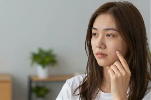 Young Asian Woman Contemplating with Plant Background
