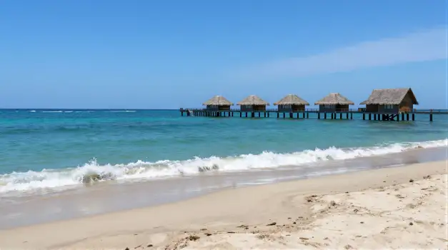 Beach Pier with Thatched Huts Over Water ocean