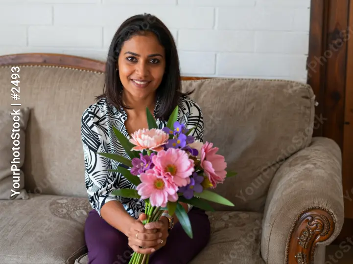 Woman Smiling with Bouquet on Couch flowers beige mother mom