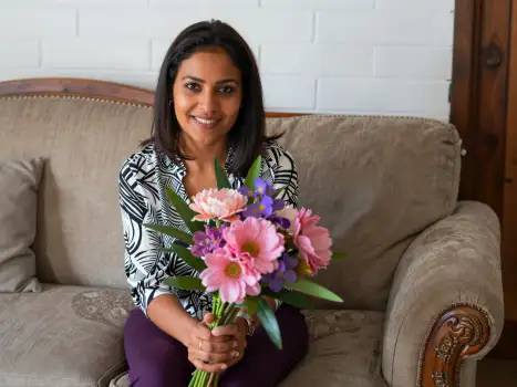 Woman Smiling with Bouquet on Couch flowers beige mother mom