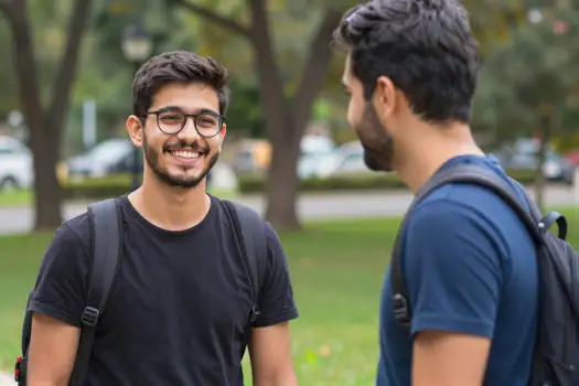 Two young men conversing in a park conversation university students