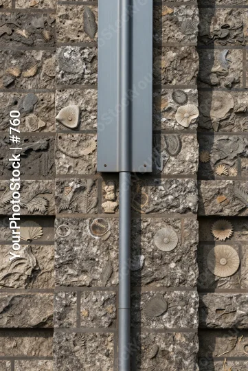 Rustic Metal Pole Attached to Brick Wall irregular stones