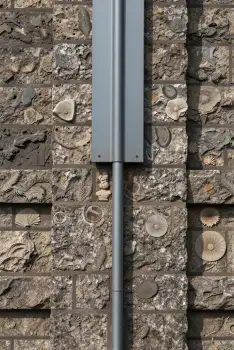 Rustic Metal Pole Attached to Brick Wall irregular stones