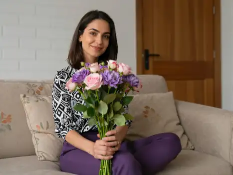 Young woman holding flowers on couch bouquet roses mom mother woman
