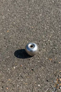 Metallic Object on Asphalt hole pebbles twigs