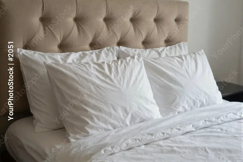Close-up of a minimalist bed with white sheets and pillows hotel