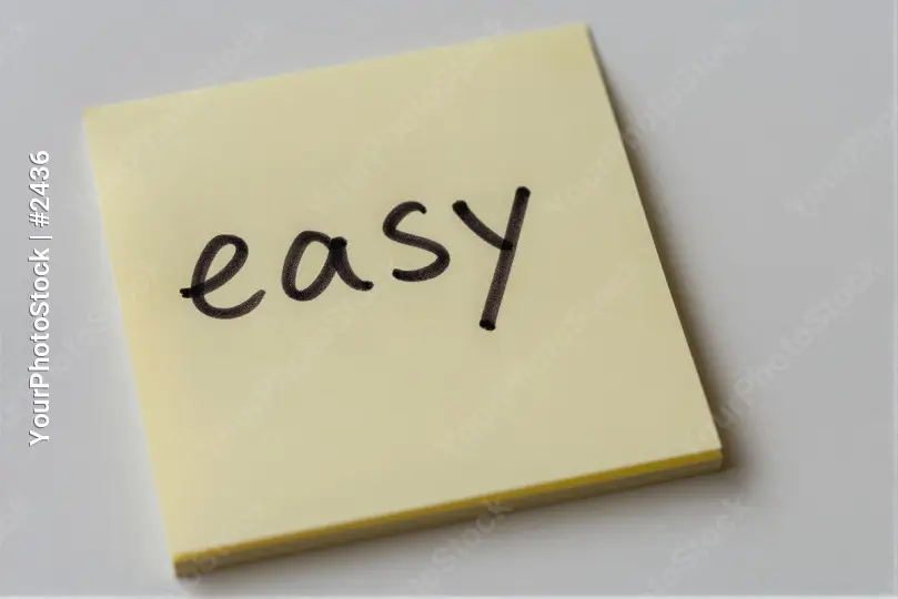 Crumpled Yellow Sticky Note with 'EASY' Written in Cursive