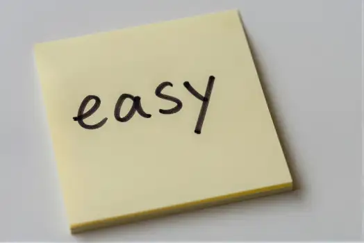 Crumpled Yellow Sticky Note with 'EASY' Written in Cursive