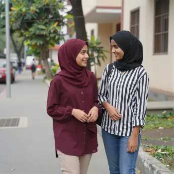 Two young women walking and chatting on a street