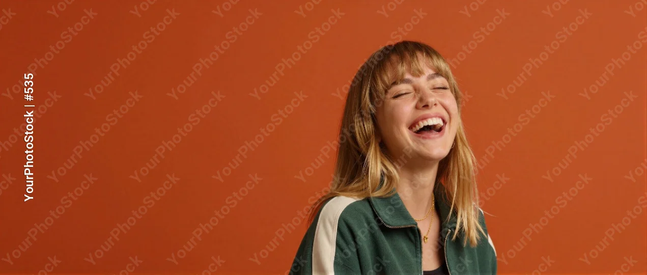 Young Woman Laughing with Closed Eyes in Green Jacket