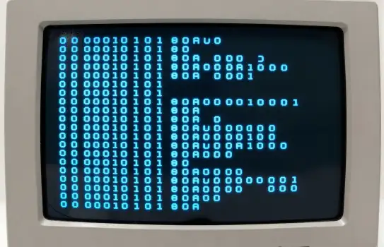Old-fashioned computer with binary code displayed on screen