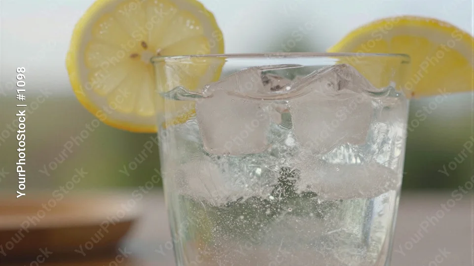 Refreshing Lemon Water with Ice on Wood Table