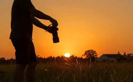 Person Taking Sunset Photo in Field taking photo