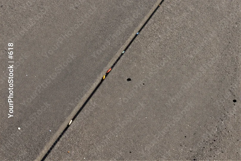 Uneven concrete line with marks asphalt hole dirt