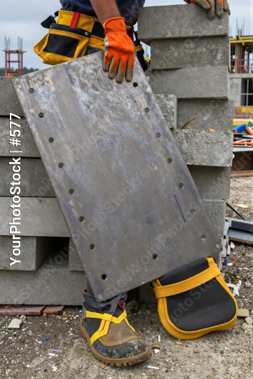 Construction Worker Holding Metal Plate building site
