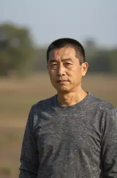 Middle-aged Asian man standing in a field serious