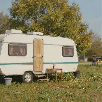 Autumnal White Caravan in Grass Field trees wooden door