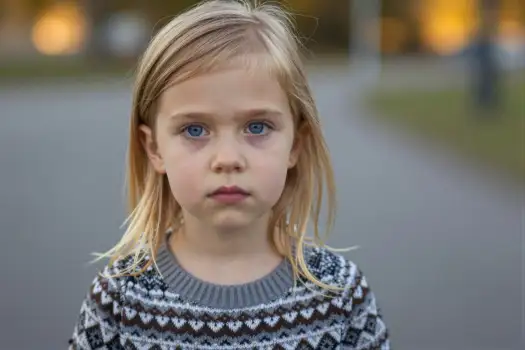 Young Girl with Serious Expression Standing on Street kid