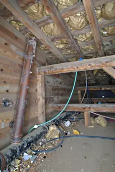 unfinished construction interior with wooden beams and insulation