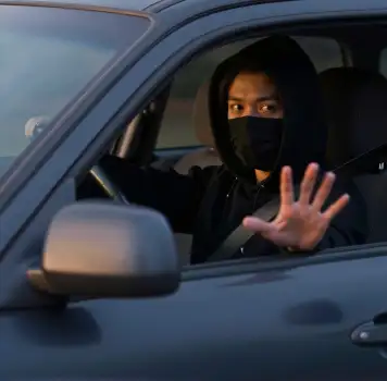 Man in Black Hoodie and Mask Making Stop Sign in Car thief