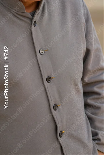 Close-up of person's upper body in light grey button-down shirt with