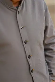 Close-up of person's upper body in light grey button-down shirt with