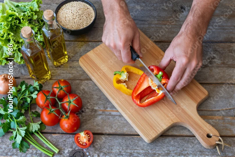 Hands Cutting Bell Pepper on Wooden Board preparing
