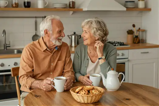 Elderly Couple Enjoying Tea and Cookies at Kitchen Table