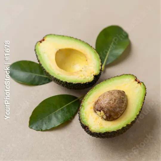 Avocado Halves with Leaves on Beige Background