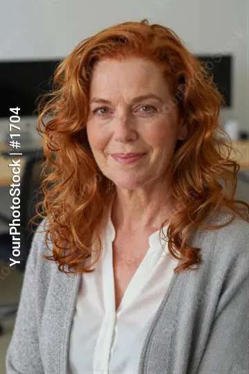 Middle-aged woman with red curly hair in office setting
