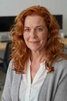 Middle-aged woman with red curly hair in office setting