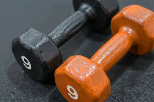 Black and Orange Dumbbells on Black Surface gym equipment