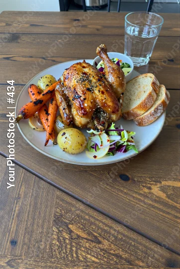 White Round Plate with Roasted Chicken and Vegetables on Wooden Table