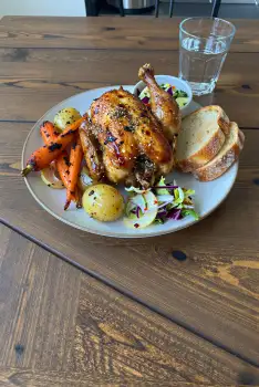 White Round Plate with Roasted Chicken and Vegetables on Wooden Table