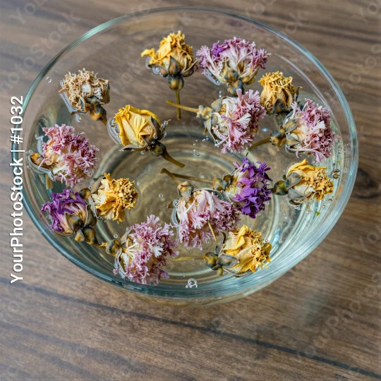Dried Flowers Floating in Water on Wooden Surface