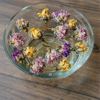 Dried Flowers Floating in Water on Wooden Surface