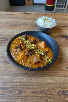 Black Bowl with Curry on Wooden Table stew meat