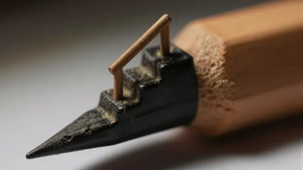 Close-up of a sharpened metal tip pencil on wooden surface